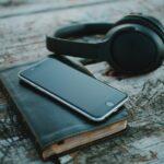 Image shows headphones, book and phone to represent audio books.