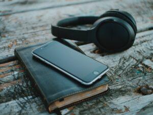 Image shows headphones, book and phone to represent audio books.