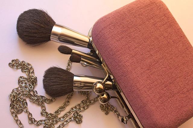 Image shows makeup brushes falling out of pink handbag