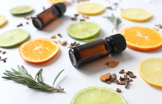 Image shows two small amber vials surrounded by slices of oranges and lime and twigs of rosemary as part of the blog on Long-Haul Flight Tips for Ultimate Comfort, Rest, and Entertainment